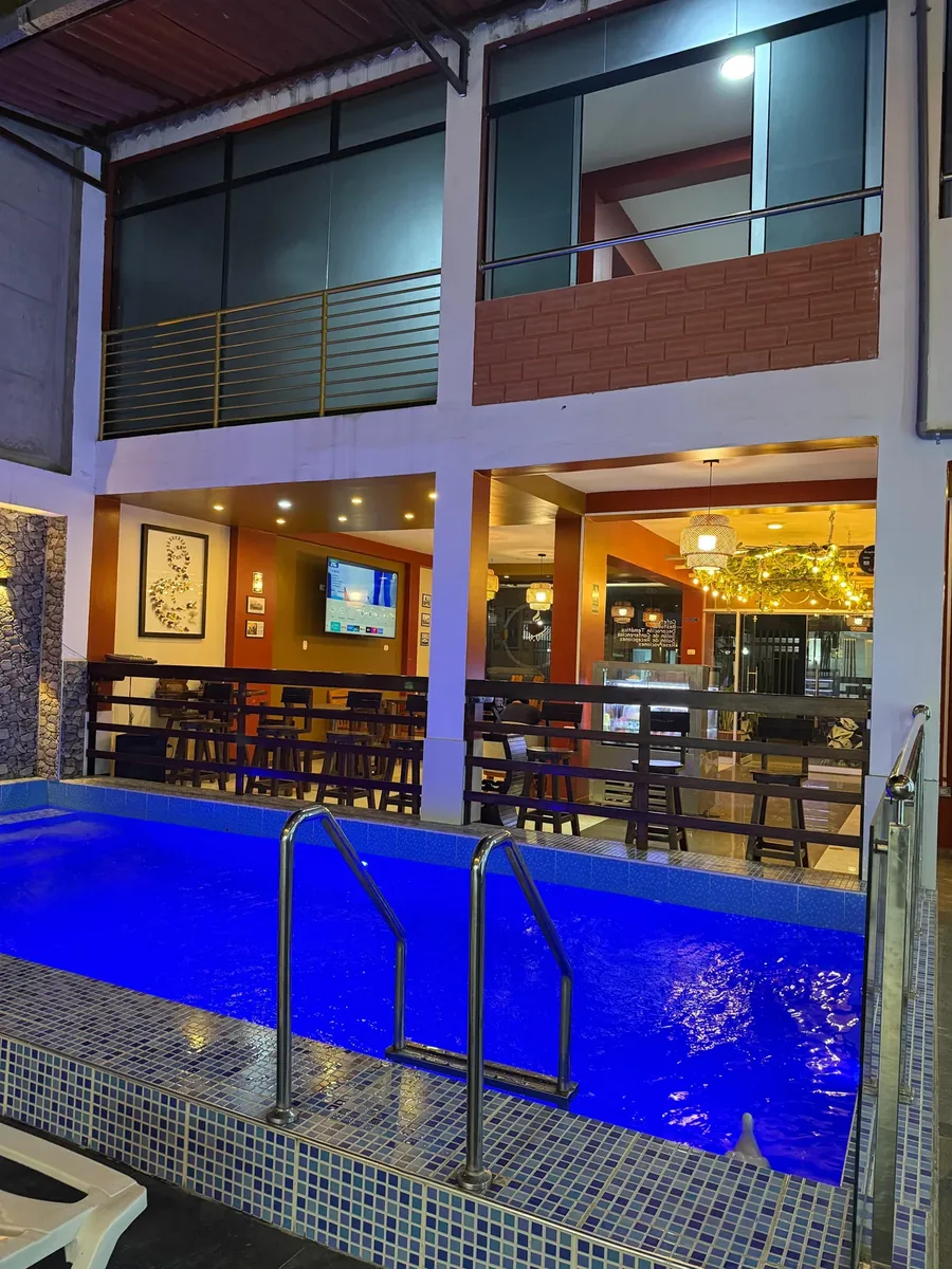 Piscina iluminada de noche con acceso de acero inoxidable en Hotel Arenas del Mayo