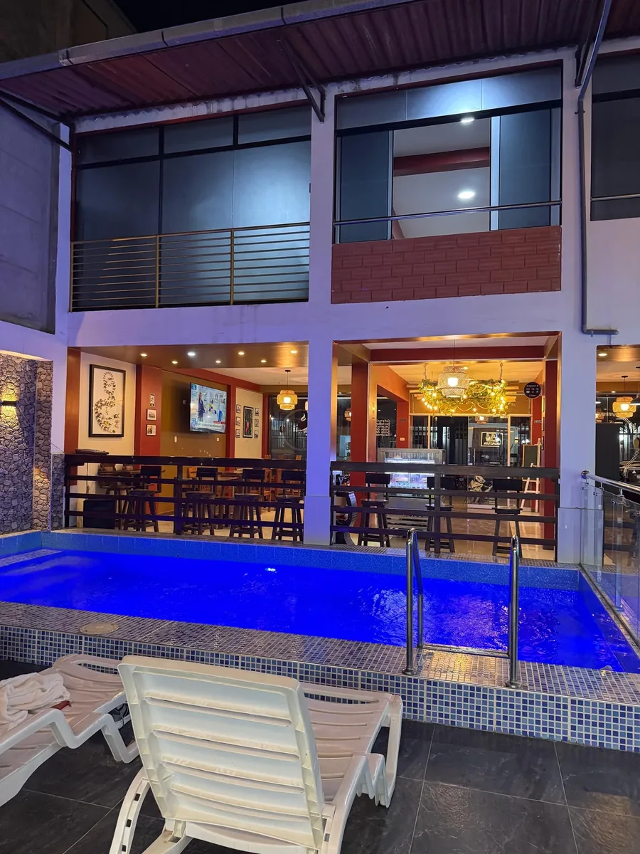 Piscina iluminada de noche con sillas de descanso en Hotel Arenas del Mayo Moyobamba