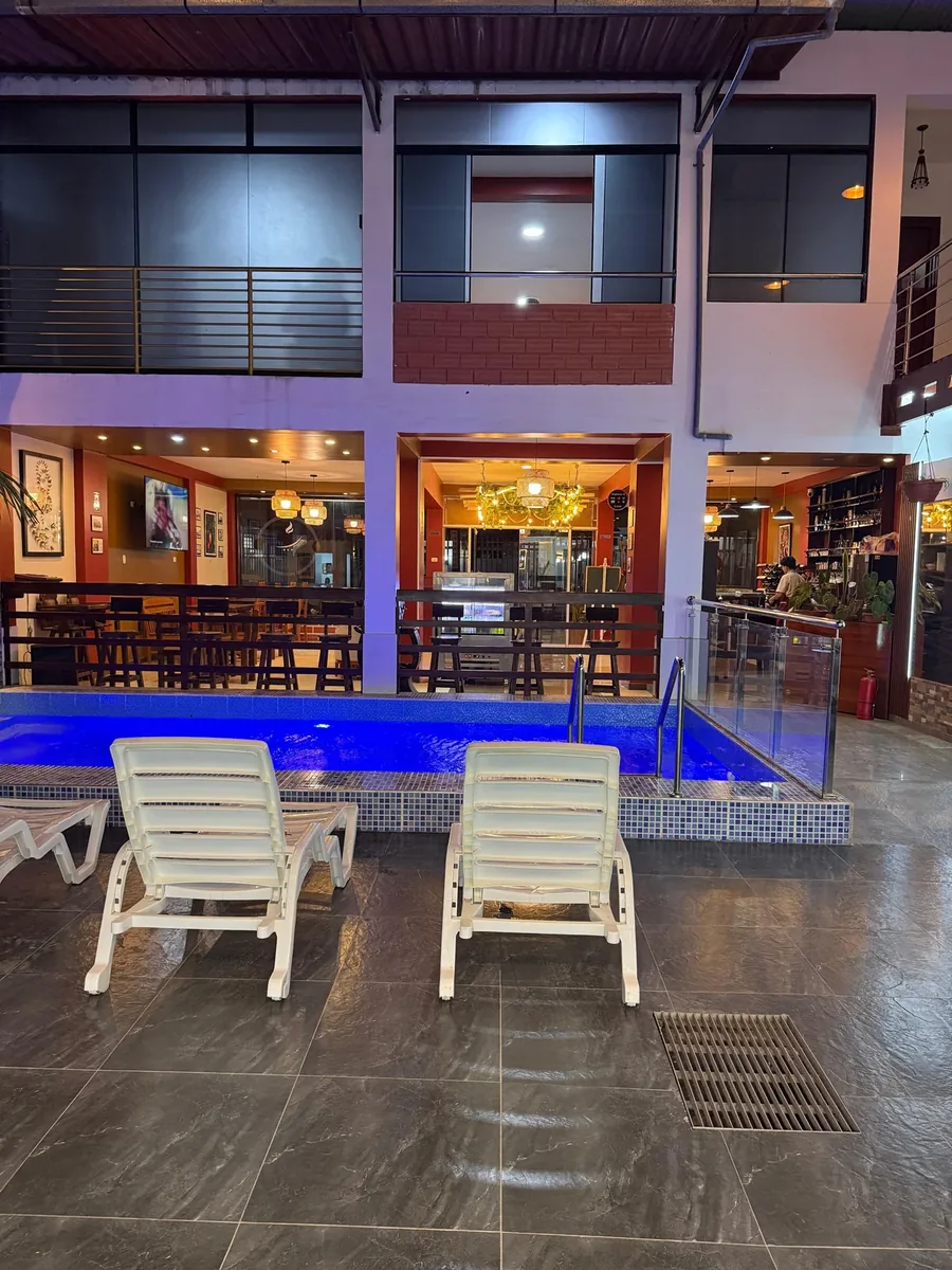 Zona de piscina de noche con reposeras frente al Restaurante Guayusa en Moyobamba